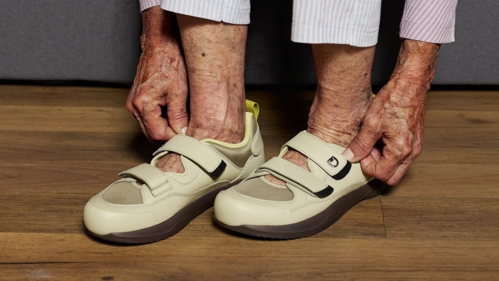 Femme âgée enfilant des chaussures confort à scratch