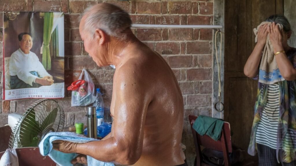Couple de seniors se rafraîchissant avec un ventilateur